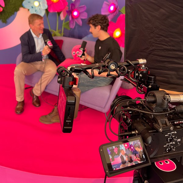 A camera rig framing Xander interviewing Tim Peake on a pink set